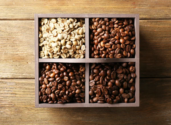Kaffeebohnen in Schachtel auf Holztisch, Draufsicht — Stockfoto