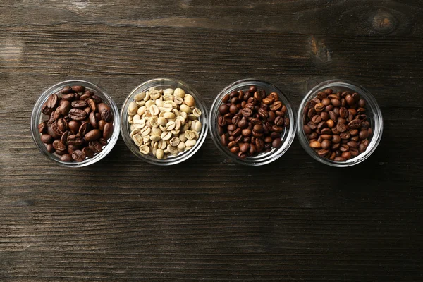 Granos de café en platillos sobre fondo de madera — Foto de Stock