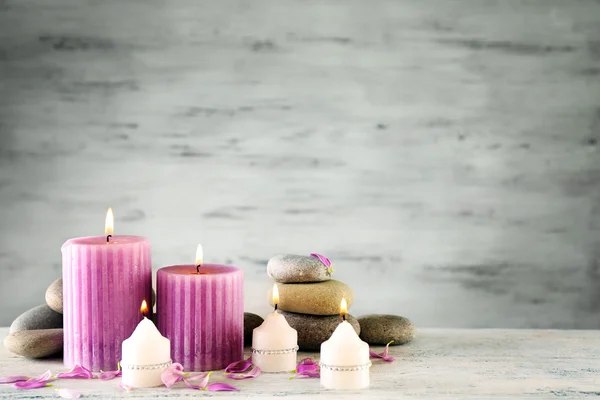 Hermosa composición con velas y piedras de spa sobre fondo de madera — Foto de Stock