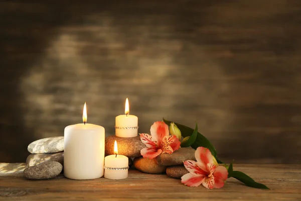 Bela composição com velas e pedras de spa em fundo de madeira — Fotografia de Stock