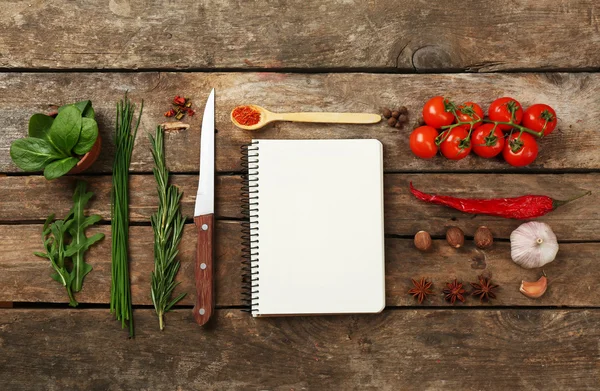 Offenes Rezeptbuch mit frischen Kräutern, Tomaten und Gewürzen auf Holzgrund — Stockfoto