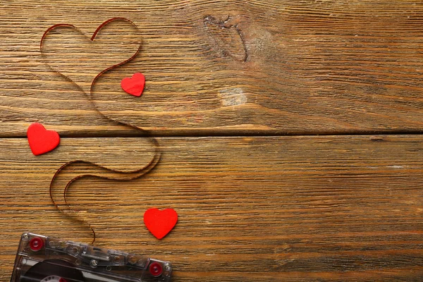 Аудиокассета с магнитной лентой в форме сердца на деревянном фоне — стоковое фото