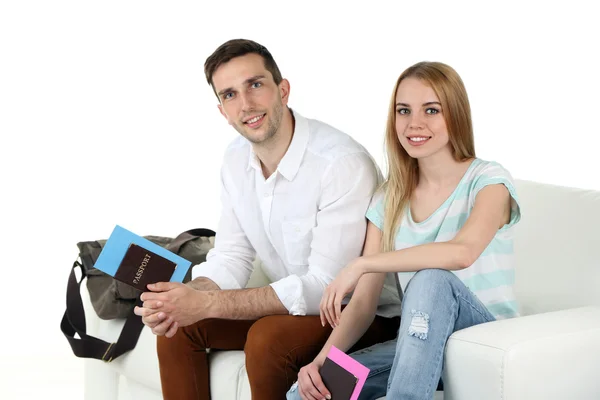 Portrét mladého šťastnému páru se zavazadly, sedí na pohovce. izolované na bílém — Stock fotografie