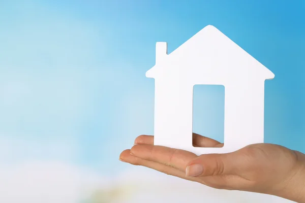 Female hand with model of house on color background — Stock Photo, Image