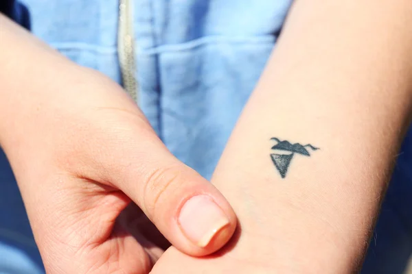 Zár-megjelöl-ból csukló fiatal nő tetoválva, hajó — Stock Fotó