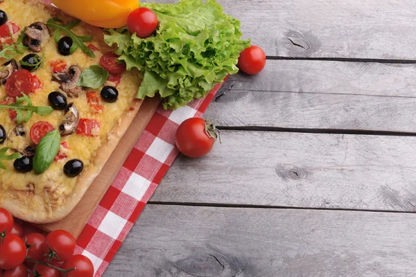 Leckere hausgemachte Pizza auf dem Tisch aus nächster Nähe — Stockfoto