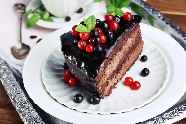 Delicious chocolate cake with berries on plate on table close up — Stock Photo, Image