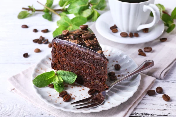 Delicioso pastel de chocolate con menta en el plato en la mesa de cerca — Foto de Stock