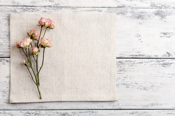 Красивые сухие цветы на салфетке на деревянном фоне — стоковое фото