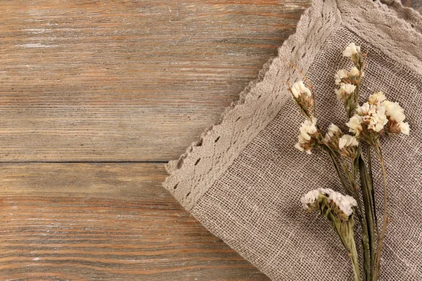 木製の背景にナプキンに美しいドライフラワー — ストック写真