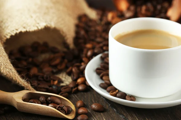 Cup of coffee with beans on table close up — Stock Photo, Image