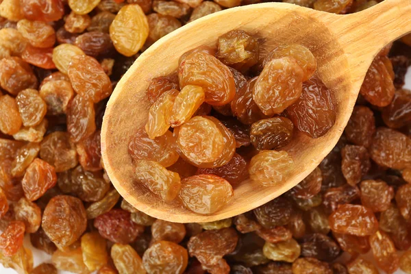 Raisins in cucchiaio di legno su sfondo uvetta — Foto Stock