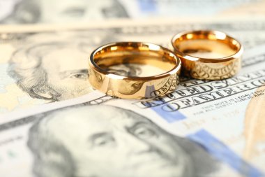 Altın alyans banknotların arka plan üzerinde. mantık evliliği