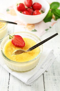 Creme brulee tatlı taze çilek ve renk ahşap zemin üzerine nane yaprakları ile
