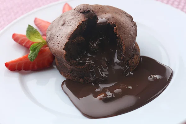Шоколадная помадка с клубникой на белой тарелке, крупным планом — стоковое фото
