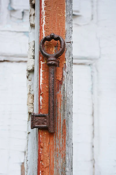 Старый ключ на деревянной старинной двери крупным планом — стоковое фото