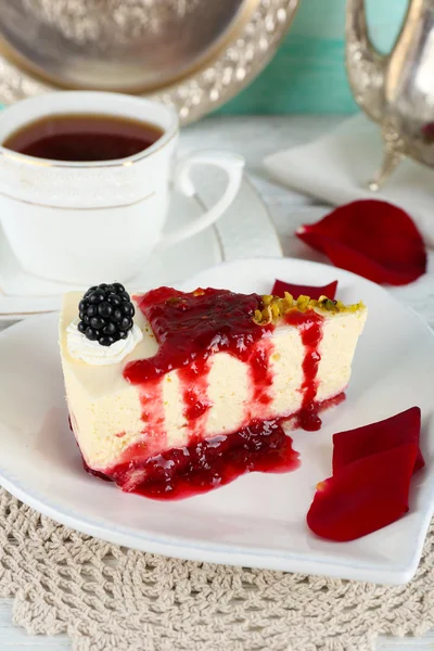 Lekker stukje cheesecake met berry saus op plaat op tafel close-up — Stockfoto