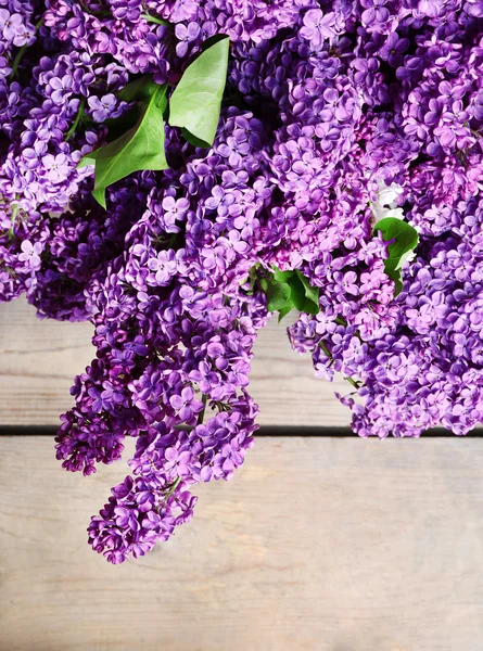 Mooie lila bloemen op houten achtergrond — Stockfoto