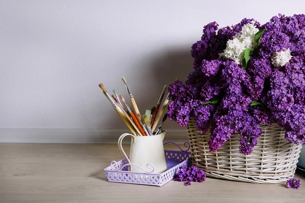 Schöne fliederfarbene Blumen auf Korb auf dem Boden in Raum Nahaufnahme — Stockfoto