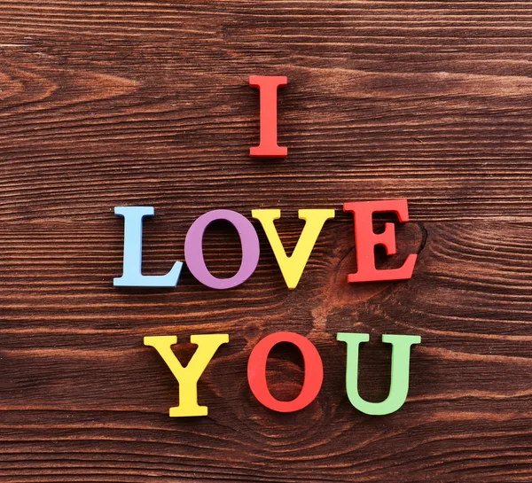 Inscription I LOVE YOU made of colorful letters on wooden background — Stock Photo, Image