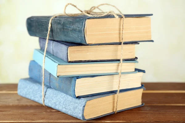 Stack of tied books on wooden table, closeup — Stock Photo, Image