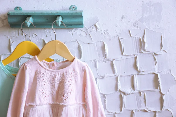 Child dress on hanger on white wall background — Stock Photo, Image