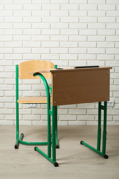 Scrivania e sedia della scuola su sfondo muro di mattoni bianchi — Foto Stock