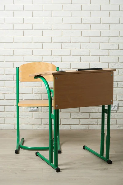 Bureau scolaire et chaise sur fond de mur en brique blanche — Photo