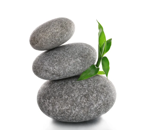 Stack of spa stones with green leaves isolated on white — Stock Photo, Image