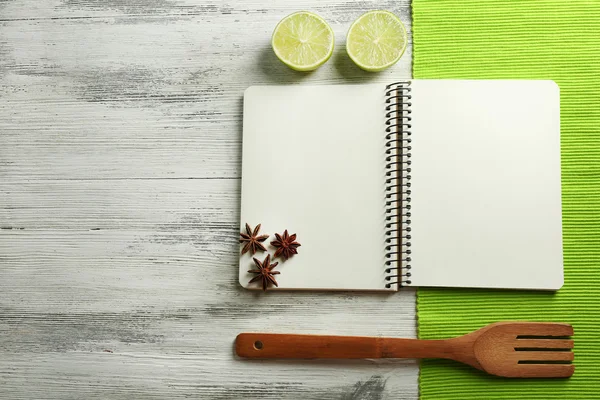 Livro de receitas aberto, guardanapo no fundo de madeira — Fotografia de Stock