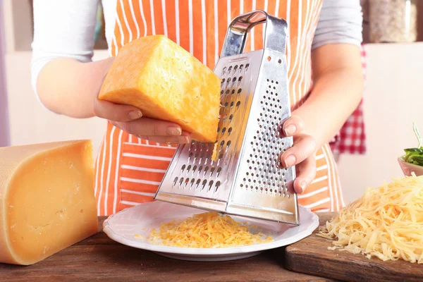 Closeup of female hands grating cheese — Stock Photo, Image