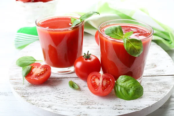 Vasos de jugo de tomate fresco en la mesa de madera, primer plano — Foto de Stock