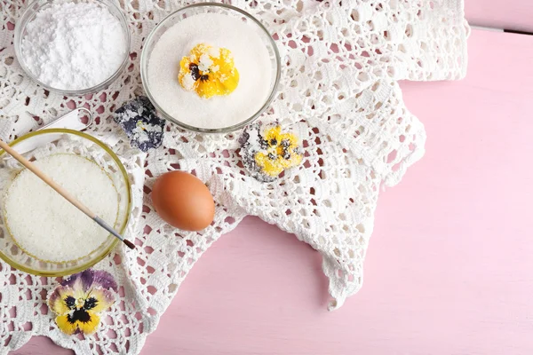 Making candied violet flowers with egg whites and sugar, on color wooden background — Stock Photo, Image