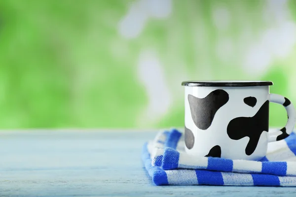 Mok van melk op houten tafel, op groene natuur achtergrond — Stockfoto