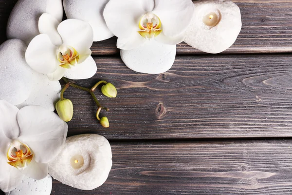 Spa stones and orchid flower on wooden background Royalty Free Stock Images