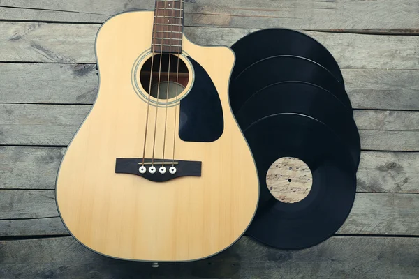 Chitarra e dischi in vinile su tavolo di legno — Foto Stock