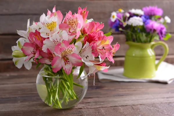 Vackra blommor i vaser på bordet — Stockfoto