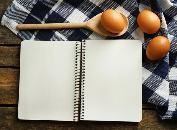 Open recipe book, eggs and napkin — Stock Photo, Image