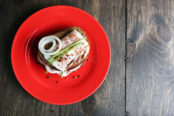 Sandwiches mit Schmalz und Zwiebeln auf Teller auf Holzgrund — Stockfoto