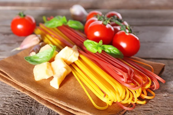 Pasta con pomodorini e altri ingredienti su fondo tavola in legno — Foto Stock