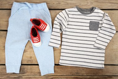 ahşap arka plan üzerinde erkek bebek için giyim