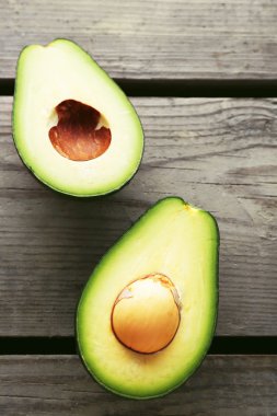 Ahşap arka planda dilimlenmiş avokado.