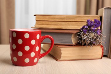 Kitaplar, kupa ve bitki üzerinde ahşap masa, portre