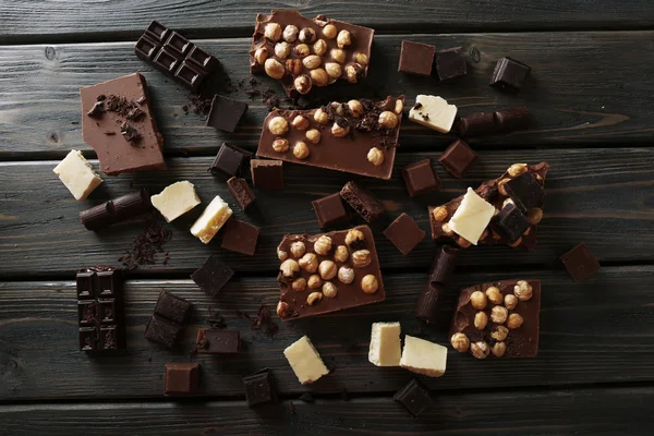 Set of chocolate with hazelnut on wooden table, top view — Stock Photo, Image