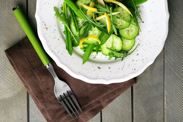 Salada verde com pepino, rúcula e casca de limão na mesa de madeira, vista superior — Fotografia de Stock