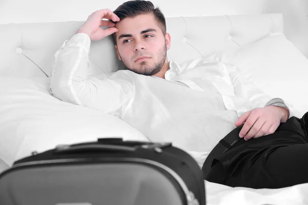 Hombre cansado descansando en la cama en la habitación — Foto de Stock