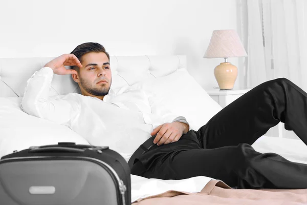 Hombre cansado descansando en la cama en la habitación — Foto de Stock