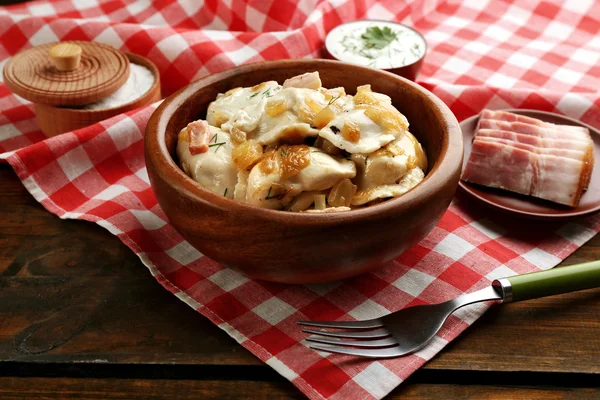 Sabrosas albóndigas con cebolla frita en tazón marrón, sobre fondo de madera —  Fotos de Stock