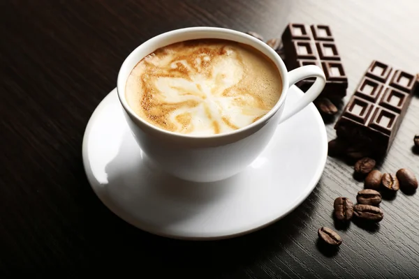 Latte art koffie met granen en staaf-van-chocolade op houten achtergrond kopje — Stockfoto