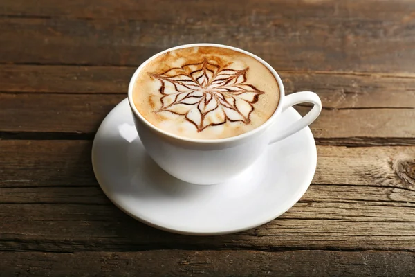 Latte sanat ahşap arka plan üzerinde kahve fincan — Stok fotoğraf